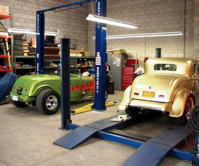 photo of 2 classic car on service lift